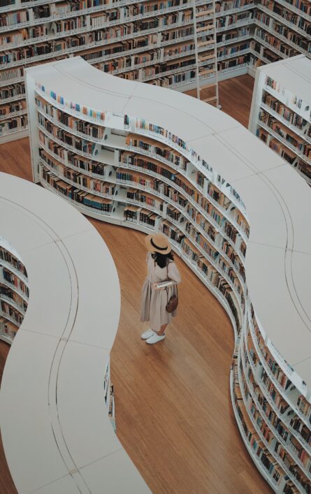 Lady standing in library with curved shelves