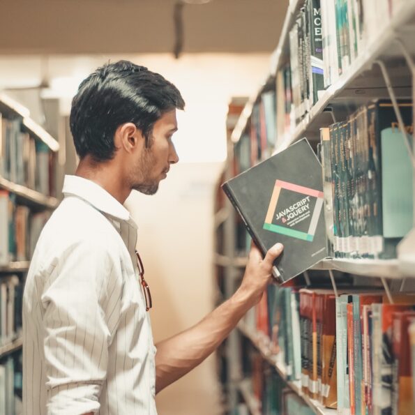 Man selecting book from library